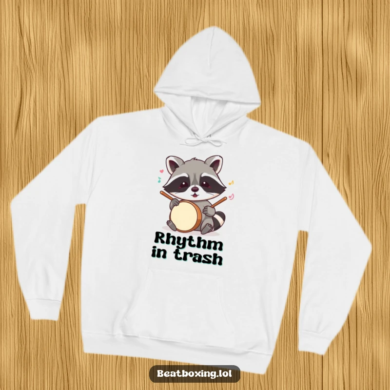 Funny raccoon hoodie showing a mischievous critter mimicking drum sounds with its paws, a cozy humorous design.